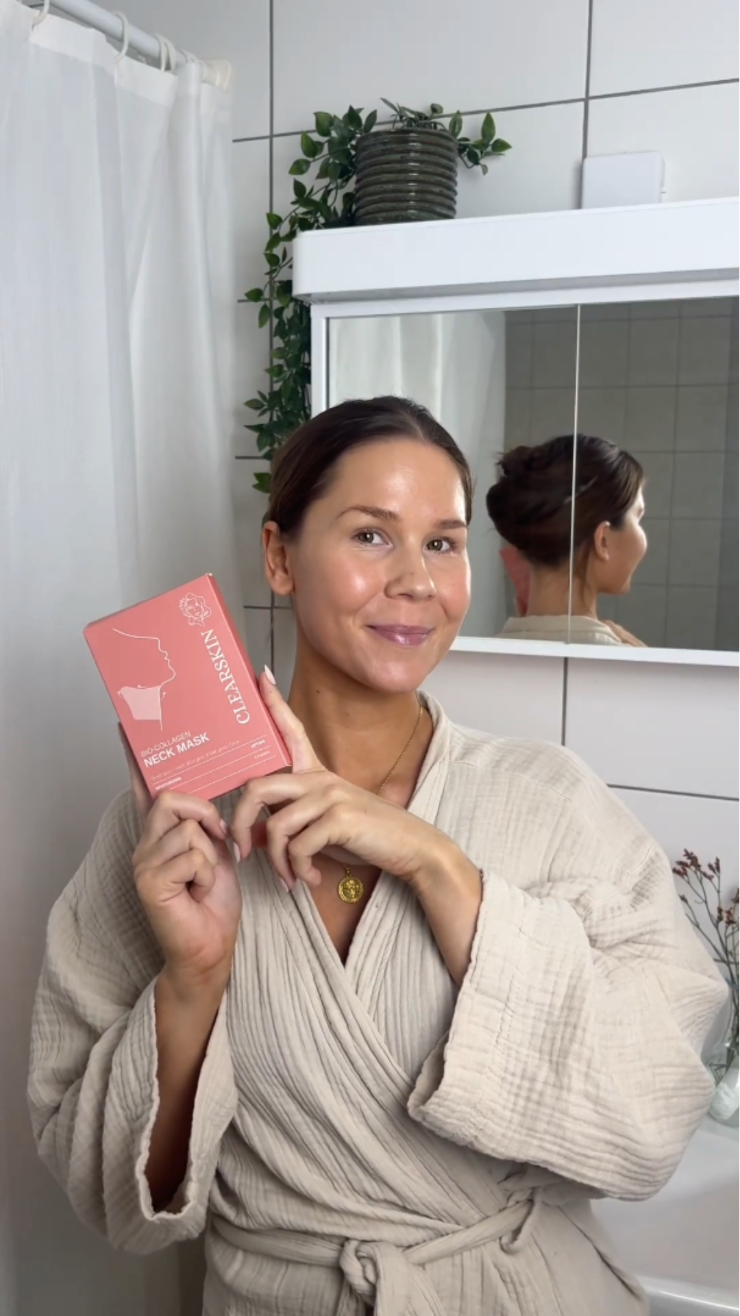 Kvinna som håller upp Clearskins kollagenmask för halsen